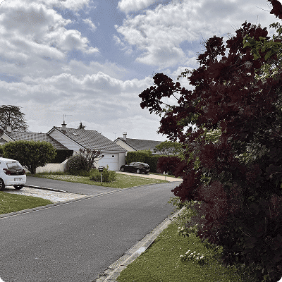 Maison individuelle avec jardin et allée pavée dans un quartier résidentiel